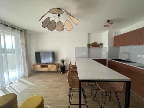une cuisine avec une table et des chaises et une télévision dans l'établissement Appartement neuf proche plage, à Sète