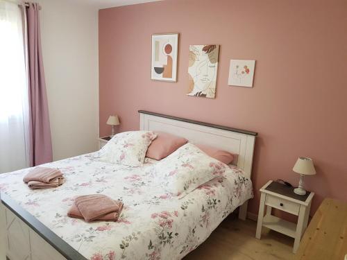 a bedroom with a bed with a floral bedspread at La Barak'A in Saint-Laurent-sur-Mer