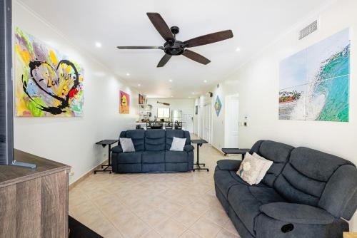 a living room with two couches and a ceiling fan at Sunrise 6- Ocean View 2 Br Condo, Steps To The Beach in Tamarindo