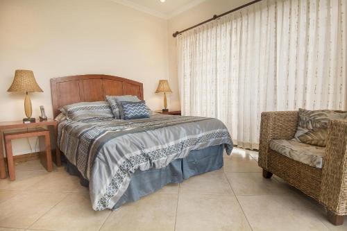 a bedroom with a bed and a chair and a window at Oceanica 824 in Playa Flamingo