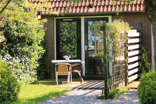 a table and chairs in front of a house at Rufus aan het water in Broek