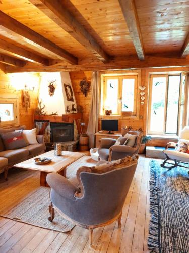 a living room filled with furniture and a wooden ceiling at "CHALET dei FIORI" room & apartment in Bedretto