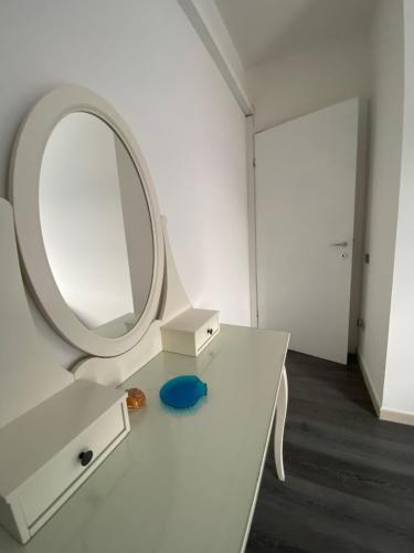a bathroom with a mirror and a white sink at Casa Sendy in Quartu SantʼElena