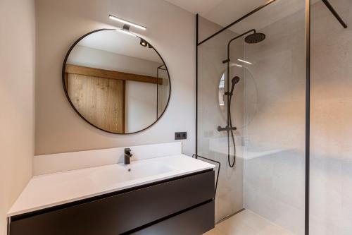 a bathroom with a sink and a mirror at Chalet 104 Westendorf by ALPS RESORTS in Westendorf