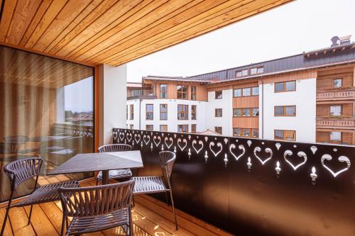 a balcony with a table and chairs and a building at Chalet 104 Westendorf by ALPS RESORTS in Westendorf