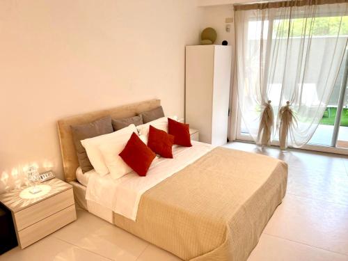 a bedroom with a large bed with red pillows at GINNY HOUSE VENEZIA in Dolo