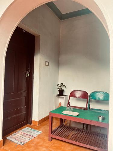 a room with two chairs and a table and a door at Paradise Inn Beach Resort in Varkala