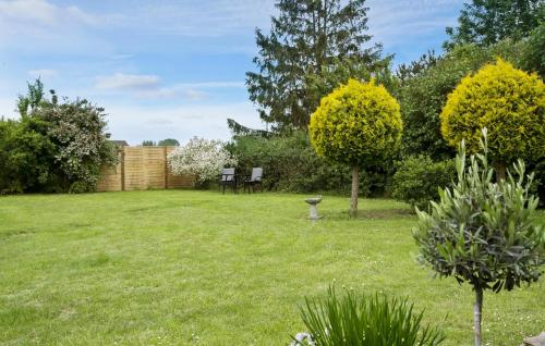 a garden with two chairs and a bird bath at 3 Bedroom Cozy Home In Eskebjerg in Eskebjerg