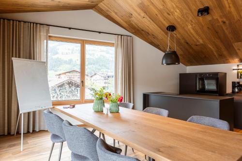 a dining room with a wooden table and chairs at Chalet 104 Westendorf by ALPS RESORTS in Westendorf