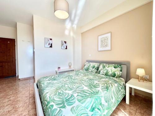 a bedroom with a bed with a green bedspread at SUN JULZ - Eden complex Sea View Studio in Chlorakas