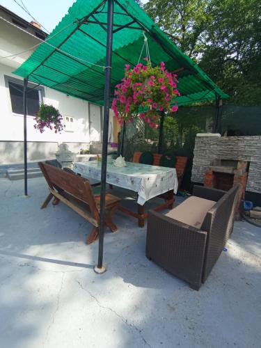a table and chairs under a green umbrella at Apartman Deni in Tuzla