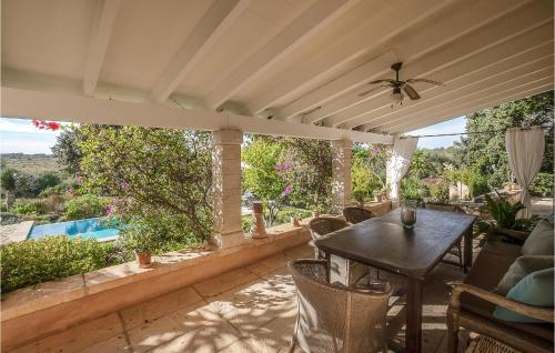 a patio with a table and a view of a pool at Lovely Home In Porto Cristo in Porto Cristo