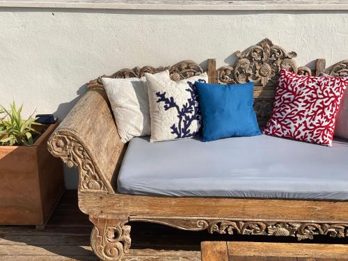 a wooden couch with pillows on it at Room Tarifa in Tarifa