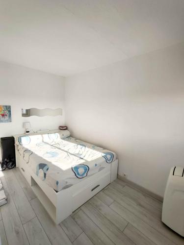 une chambre avec un lit blanc dans une pièce dans l'établissement Appartement sur le port, à Leucate