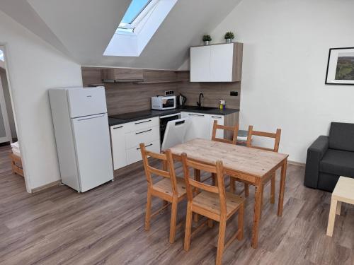 a kitchen and dining room with a table and chairs at Apartments Otre Frymburk in Frymburk