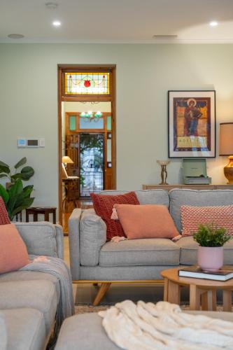 a living room with two couches and a table at Stanley Stay - Sauna, Play set, WiFi, Central Location in Woodville