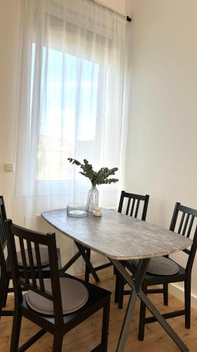 a wooden table with chairs and a vase with a plant at Apartment Savanna im historischen Stadtkern Linn in Krefeld, nähe Düsseldorf Messe, Airport, Parkmöglichkeiten direkt vor dem Haus in Krefeld