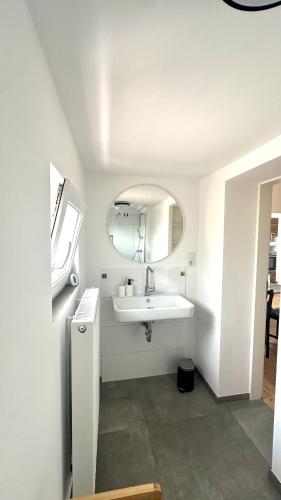 a white bathroom with a sink and a mirror at Apartment Savanna im historischen Stadtkern Linn in Krefeld, nähe Düsseldorf Messe, Airport, Parkmöglichkeiten direkt vor dem Haus in Krefeld