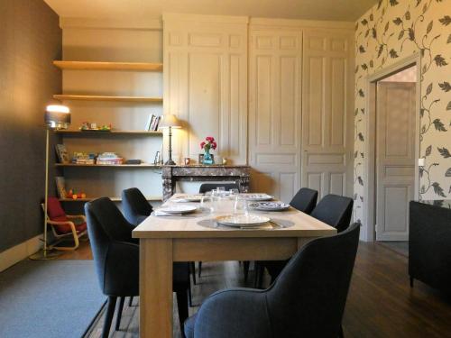 a dining room with a wooden table and chairs at villa Aristide Courville in Courville-sur-Eure