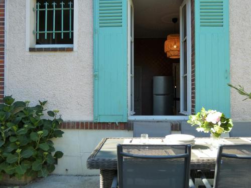 a table and chairs on the porch of a house at villa Aristide Courville in Courville-sur-Eure