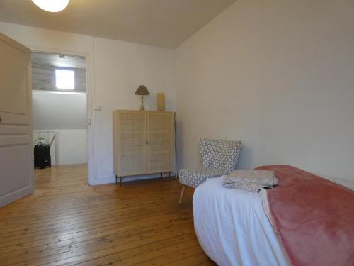 a bedroom with a bed and a chair and a dresser at villa Aristide Courville in Courville-sur-Eure
