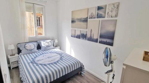 - une chambre avec un lit et des photos sur le mur dans l'établissement Cosy Appart - proche mer et toute commodités, à Nice