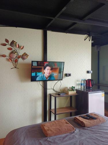 a tv on a wall in a room with a bed at Chill & View ชิววิว เขาค้อ in Ban Huai Phai
