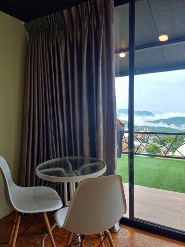 a table and two chairs in front of a window at Chill & View ชิววิว เขาค้อ in Ban Huai Phai