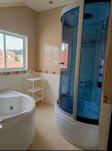 łazienka z prysznicem, wanną i umywalką w obiekcie Cómodo departamento w mieście Cuenca