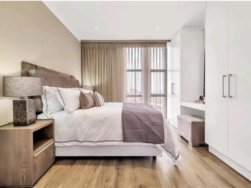 ヨハネスブルグにあるApartment Towers in Sandton- with luxury Spaの大きなベッドと窓のある白い寝室