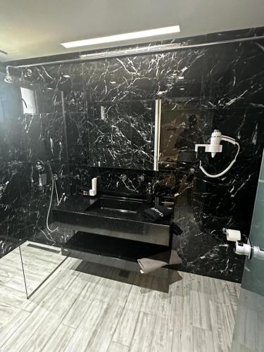 a bathroom with a black marble wall at Aithra in Paradisos