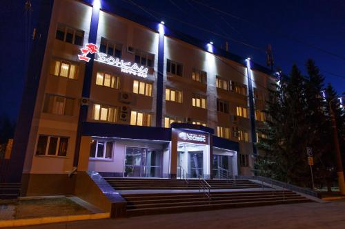 a hotel building with a sign on it at night at Cosmos Business-Hotel in Kurgan