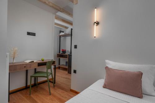 a bedroom with a desk and a bed with a green chair at Arca Deorum in Vytina