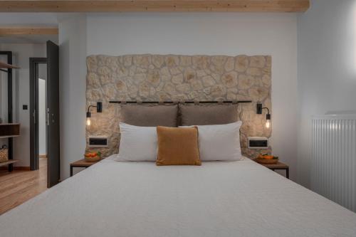 a bedroom with a large bed with white pillows at Arca Deorum in Vytina