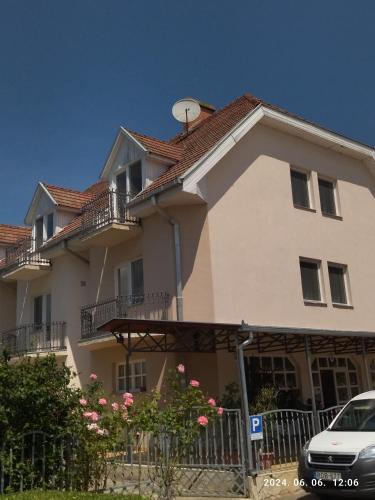 a large house with a car parked in front of it at Start Panzió-Étterem in Hajdúszoboszló
