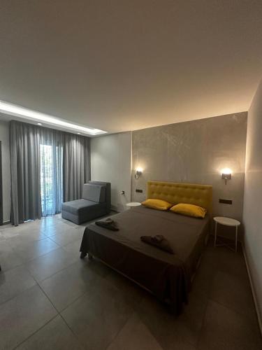 a bedroom with a large bed and a chair at Aithra in Paradisos
