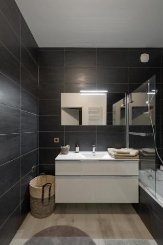 une salle de bain avec un lavabo blanc et un miroir dans l'établissement Appartement 3 chambres confluence haut standing 6 personnes, à Lyon