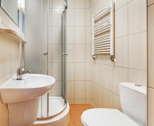 a white bathroom with a sink and a toilet at Willa Wilk Morski in Jastrzębia Góra