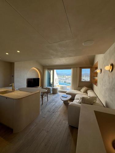 un grand salon avec un canapé et une table dans l'établissement Golfe de St-Tropez somptueux appartement vue port et mer, à Cogolin