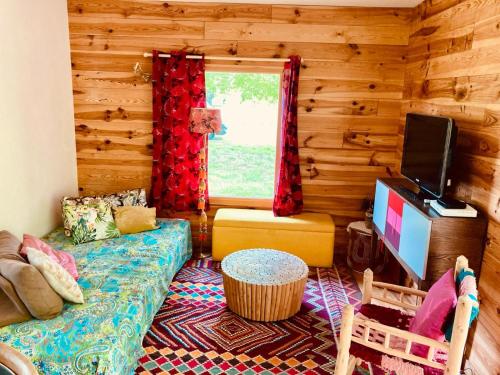 un salon avec un canapé et une télévision à écran plat dans l'établissement Eco-Friendly Boho Loft Chalet, à Saint-Julien-en-Born