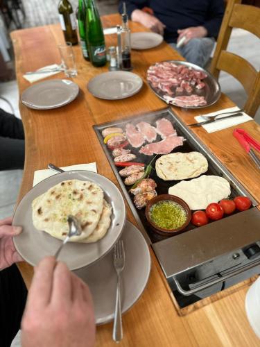 a person holding a plate of food on a table at Guesthouse Jurcek in Zreče