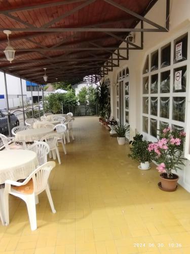 an empty patio with tables and chairs and flowers at Start Panzió-Étterem in Hajdúszoboszló