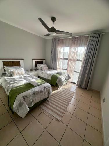 a bedroom with two beds and a ceiling fan at Luxury 3 Bedroom in Bondi Beach Resort in Shelly Beach