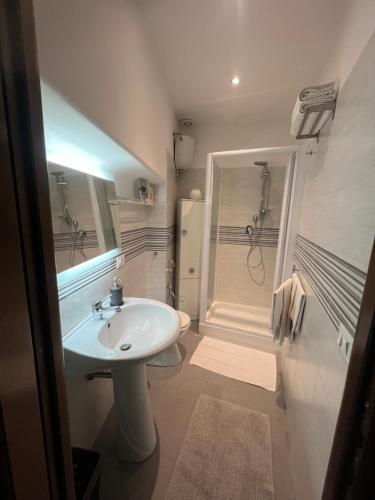 a white bathroom with a sink and a shower at Correa Vatican Hospitality in Rome