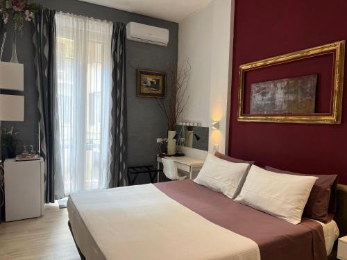 a bedroom with a large bed with a red wall at Correa Vatican Hospitality in Rome