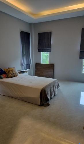 a bedroom with a bed and two windows at ไกล้ทะเลอยู่แบบธรรมชาติ in Ban Khao Yai Chum