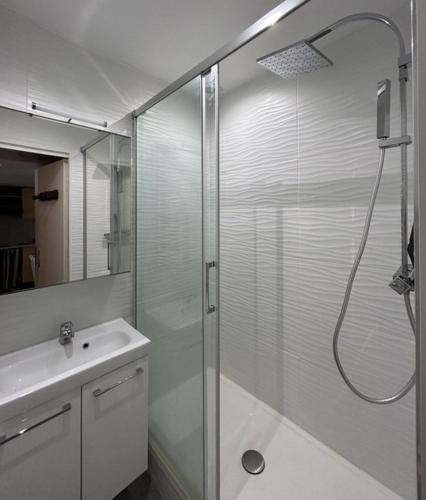 une salle de bain avec une douche en verre et un lavabo dans l'établissement Maisonnette, résidence au calme avec terrasse et parking privé 4AM21, au Barcarès