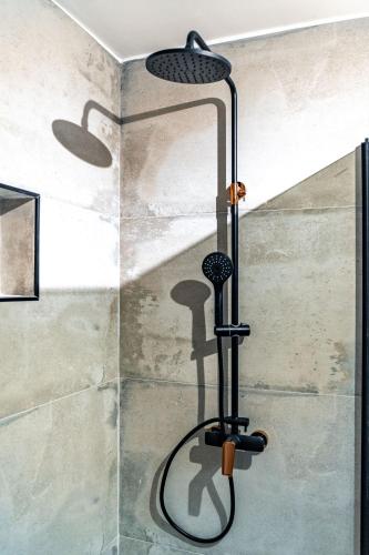 a shower in a bathroom with a shower head at Grgurić Apartments in Rab