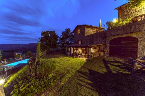 an external view of a stone house with a swimming pool at Agriturismo La Sala in Greve in Chianti