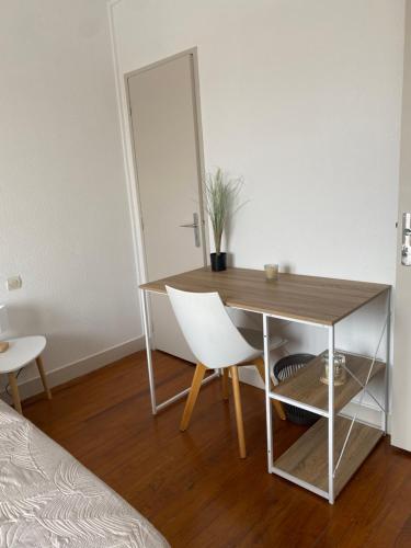 une pièce avec une table, une chaise et un miroir dans l'établissement Appartement Cosy vue sur la cathédrale Albi, à Albi